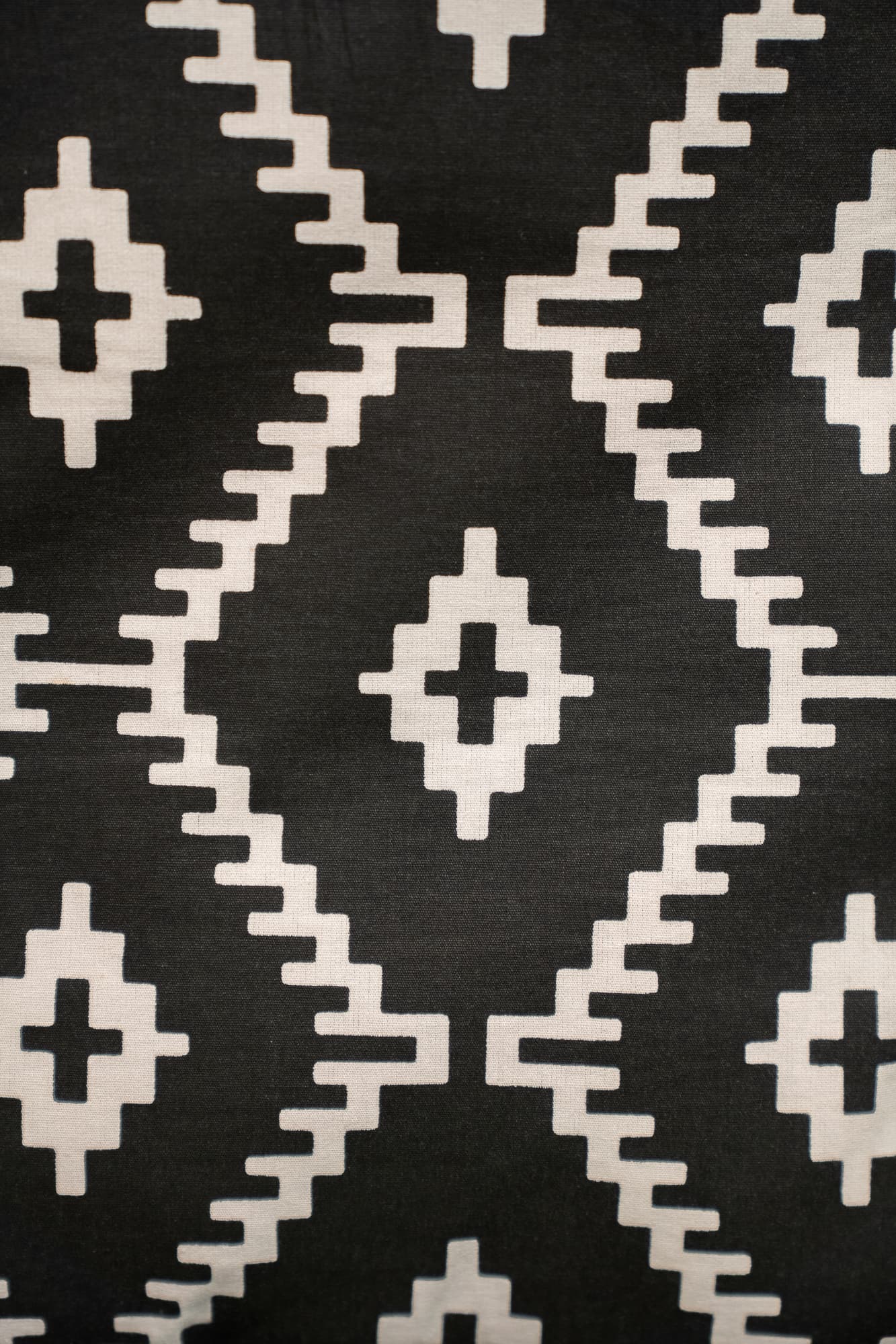 black cushion with white diamond pattern and tassels