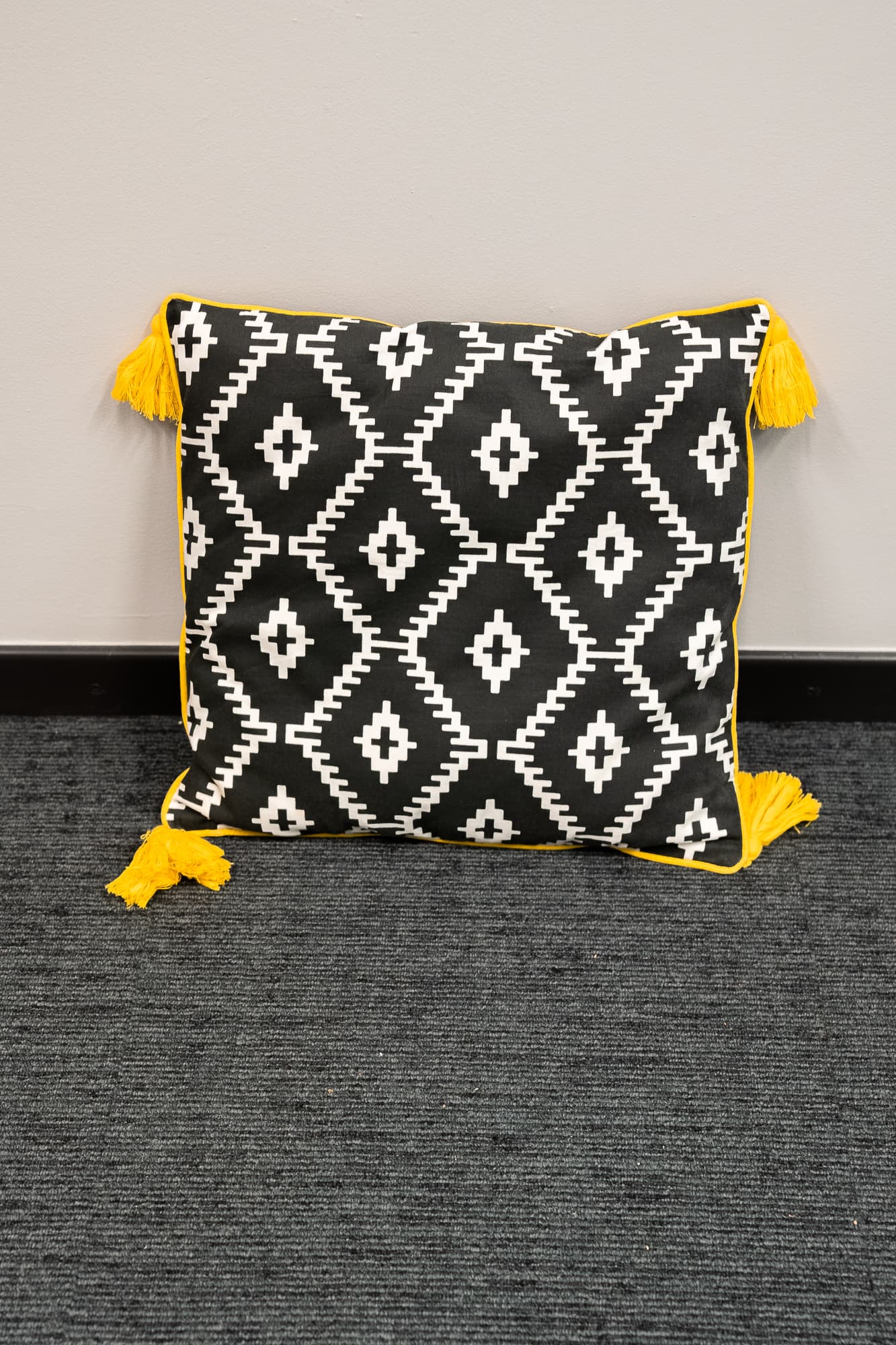 black cushion with white diamond pattern and tassels